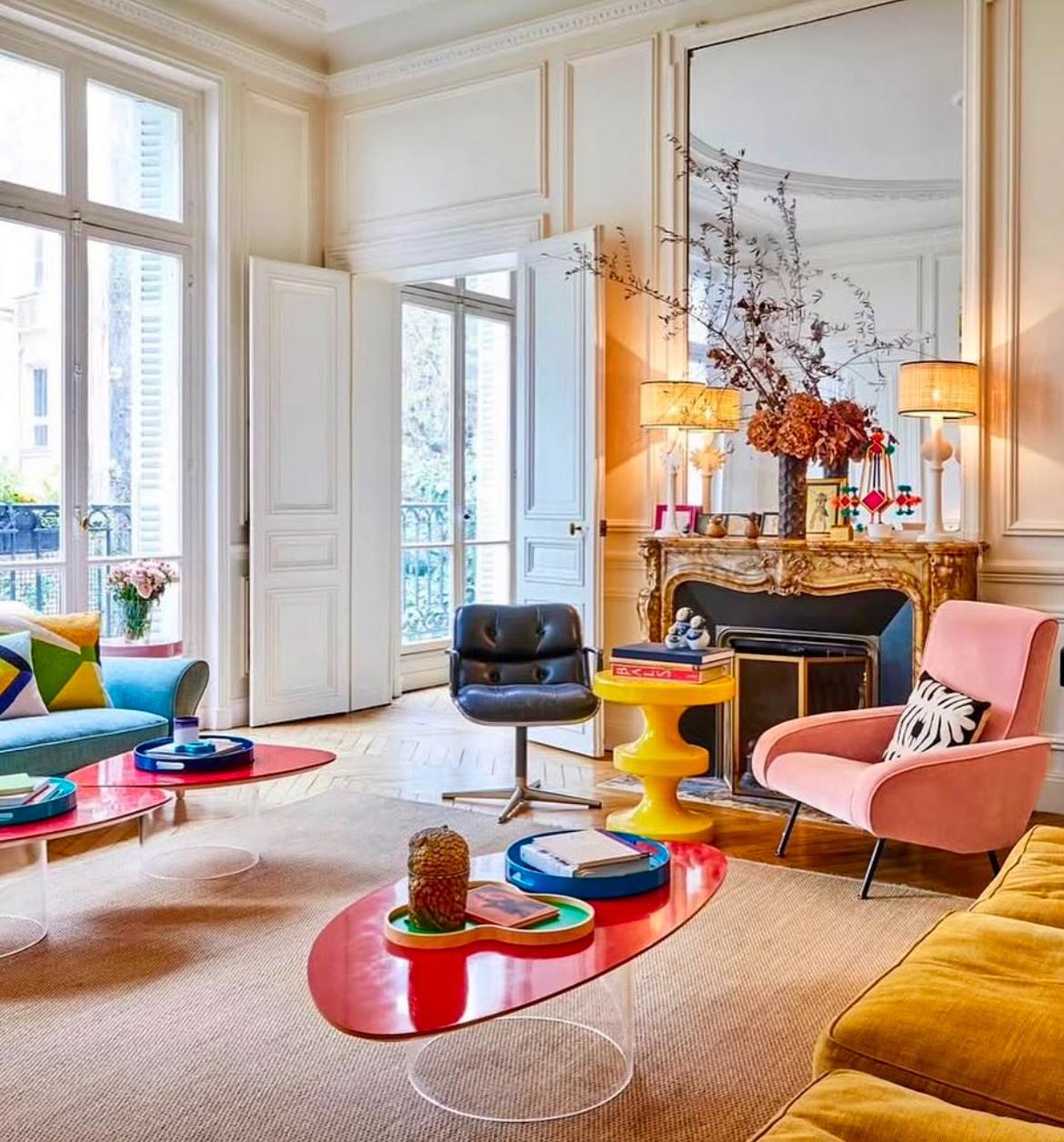 Salón moderno con muebles coloridos, alfombra clara y grandes ventanales decorados.